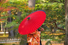 在传统伞下的传统服饰夫妇，肯罗库