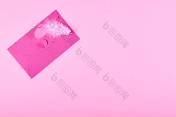 粉红背景构图上的包皮和羽毛.平铺相片.