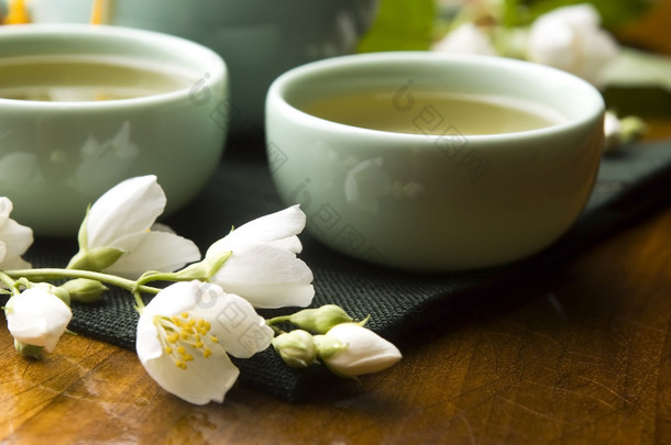 绿茶与茉莉花在杯子和木桌上的茶壶