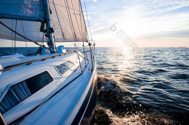 日落时航行。从游艇甲板到船头和船帆的景色.特写。波罗的海，拉脱维亚