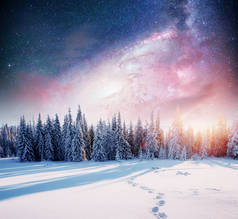 在冬雪的夜空中繁星闪烁。梦幻般的银河在除夕夜。银河是一个梦幻般的新年前夜。冬天的路在山上。美国宇航局的礼遇. 