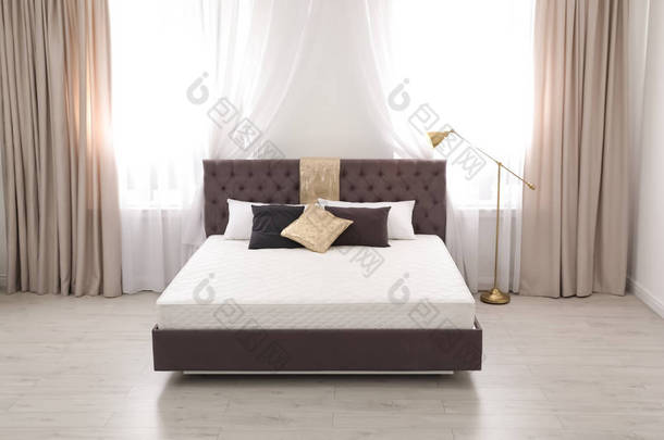 舒适的床, 新床垫靠近窗户在房间里。健康睡眠