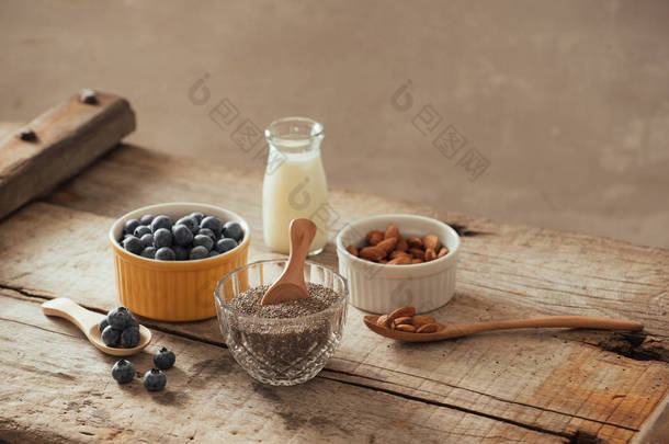 新鲜的蓝莓、杏仁和嘉亚种子, 木板上有牛奶。理想的健康早餐理念. 