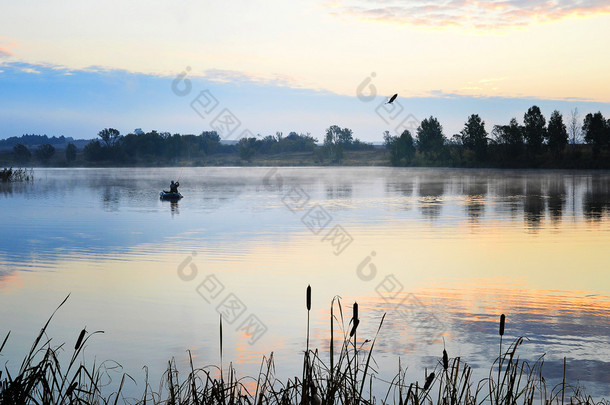 一位渔民在晨雾中航行的一艘船