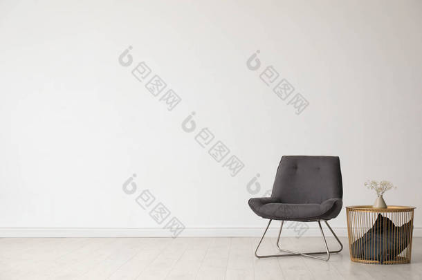 时尚的客厅内部，舒适的椅子和靠近<strong>白色</strong>墙壁的边桌。文本空间