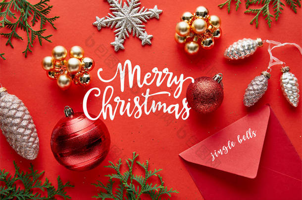 明亮的<strong>圣诞装饰</strong>、信封和红色背景的thuja的顶部视图，附有圣诞快乐的插图