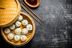 在竹蒸机中用酱油在盘子里吃的香肠饺子.