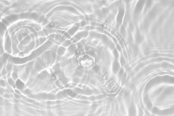模糊的、透明的、透明的、清晰的、平静的水面纹理，带有水花和气泡。潮流抽象的自然背景.阳光下的白灰水波。复制空间.