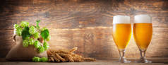 啤酒杯，麦穗，木制背景的啤酒花