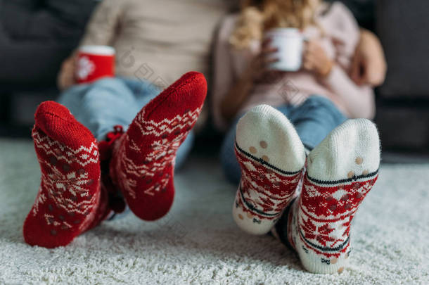 夫妇持有杯卡布奇诺与圣诞袜子在家里的前景的短图像