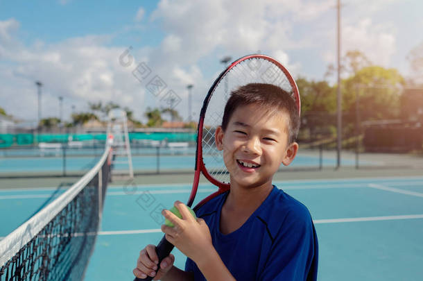 年轻的亚洲男孩网球运动员在室外蓝色法院