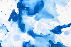 蓝色飞溅的酒精墨水在白色作为抽象背景 