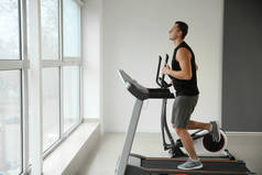 运动的年轻人在跑步机上的健身房