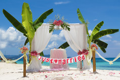婚礼拱门和建立起来的具有热带海滩上的花朵
