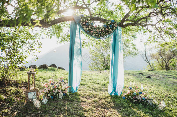 夕阳西下的婚礼拱门，装饰着花朵和蓝色丁香