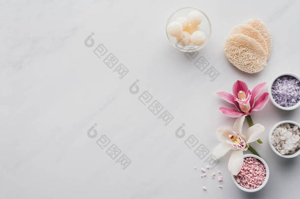 美丽的兰花花, 碗中的海盐和白色背景海绵的顶部视图 