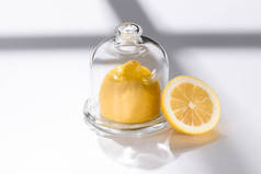 关闭白色桌面玻璃器皿中新鲜柠檬的特写图