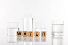 在立方体附近的玻璃杯中清澈的淡水，用白色隔水字体隔开