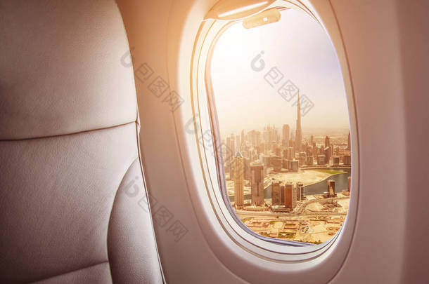 飞机内部与迪拜城市, 阿联酋的窗口视图。旅行和空运概念