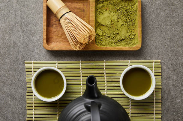 在绿桌垫上用<strong>茶</strong>和红<strong>茶</strong>壶的白杯顶视图，靠近竹须和船上的火柴粉