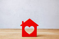 红房子的心, 甜蜜的家。灰墙背景下的木墙房屋标志