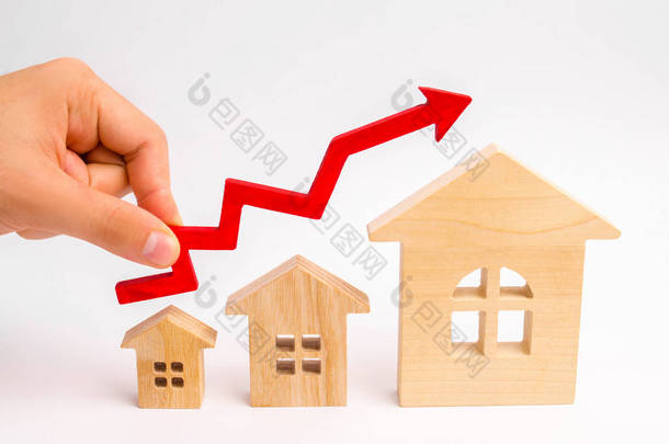 木房子从小到大站在一排, 红色箭头向上。房地产需求高的概念。提高住房的能效。房价上涨。财产.