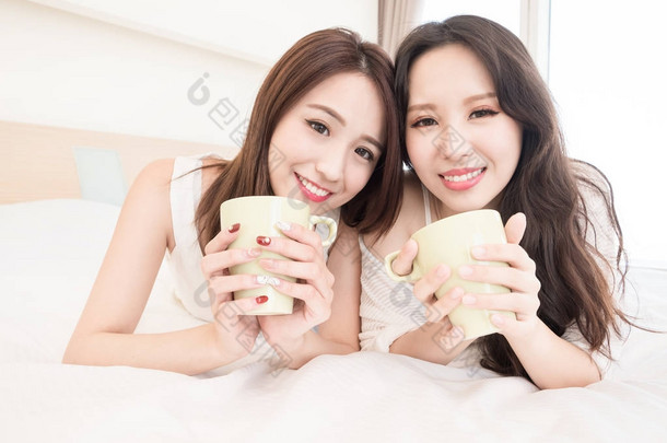 两个美女在家里用<strong>杯子</strong>微笑