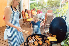 在花园里与妈妈和女儿一起在烤架上举行烧烤派对