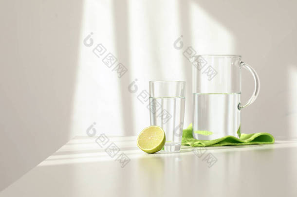 在<strong>浅色背景</strong>下, 在桌子上的淡水和石灰的玻璃器皿。文本的空间
