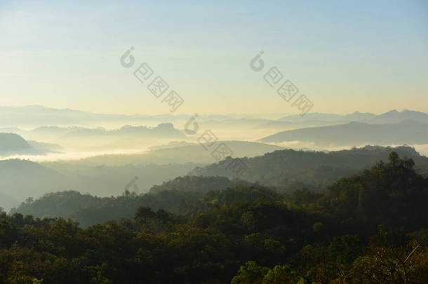 美丽的天空和金色的云彩。日出前的群山。清晨。太阳从山顶升起.