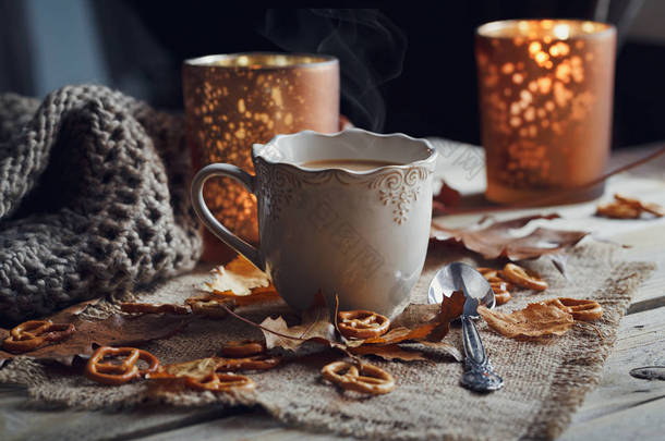 秋天的树叶，热杯热气腾腾的咖啡和一个<strong>温暖</strong>的围巾