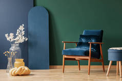 复古深蓝色扶手椅在优雅, 客厅内部与复制空间在空绿色和蓝色的墙壁
