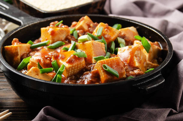 麻婆<strong>豆腐</strong>在铁锅中，配以猪肉切碎、酱油、西川胡椒大蒜和调味品