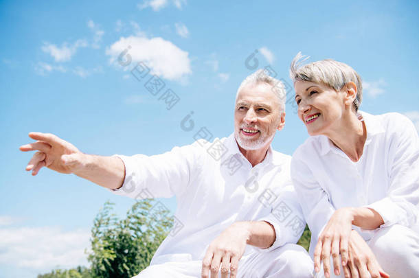 幸福的笑容老年夫妇在白色<strong>衬衫</strong>望向蓝天