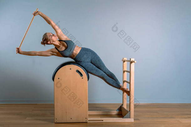 漂亮的女人做普拉提运动，在桶上训练。健康的概念，特殊的健身设备，健康的生活方式，塑料。复制空间，<strong>体育广告</strong>横幅.
