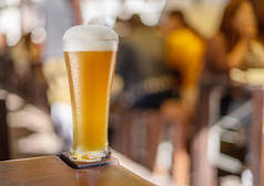 一杯啤酒站在酒吧的桌子上. 不加过滤的白啤酒.