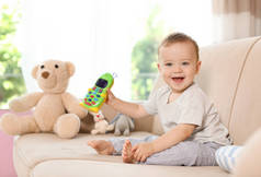 家庭沙发上的玩具手机可爱的小宝宝