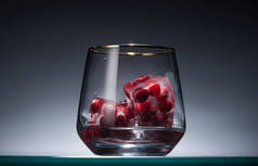 透明玻璃杯，冰块里有冻红，背光里有伏特加