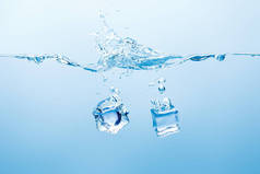 纯水与飞溅和冰块的蓝色背景