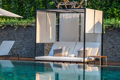 室外游泳池, 周围有伞式椅子休息室, 提供休闲旅行和度假的概念