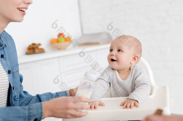 母亲<strong>喂养</strong>小男孩与牛奶在厨房