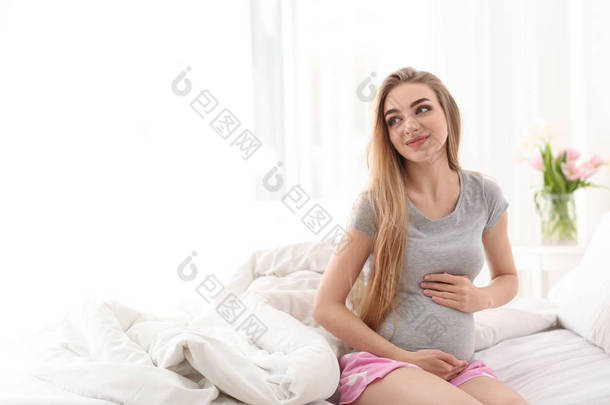 在家床上的年轻怀孕妇女