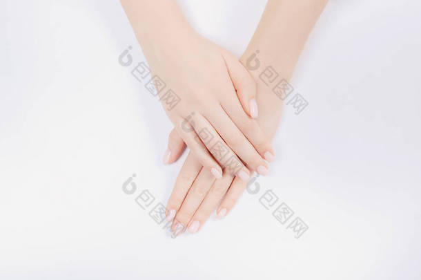 时尚的指甲年轻女人用粉红的指甲在白色的背景上修指甲