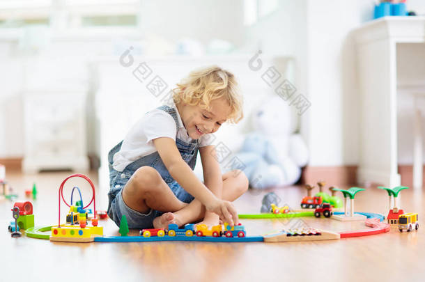 孩子们玩木铁路。儿童与玩具火车.