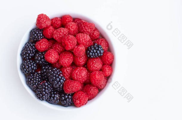 在白色的新鲜和成熟的覆盆子和黑<strong>莓</strong>的盘子上的顶部视图