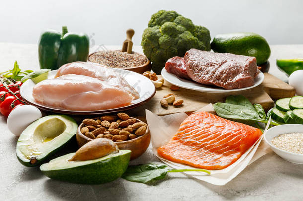 生鲑鱼，肉和鸡胸肉附近的<strong>绿色</strong>蔬菜分离在灰色，生酮饮食菜单
