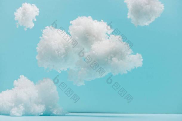 用棉花制成的白色蓬松的云彩，与蓝色隔离