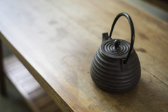 在木桌上的传统日本黑茶壶