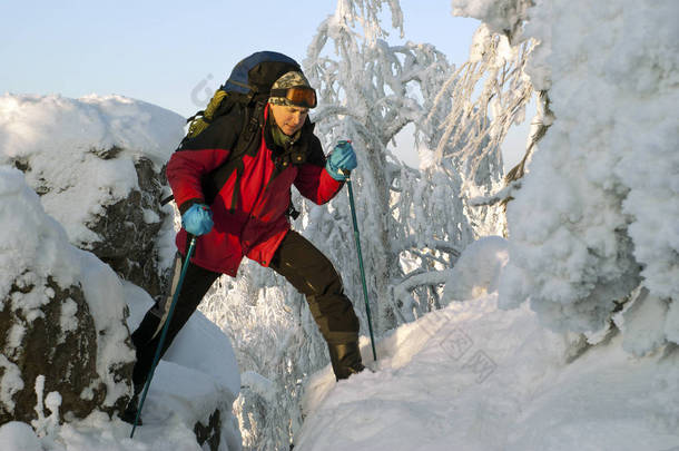旅行者与背包在美丽的冬天山风景超越峭壁