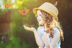 手上拿着一只蝴蝶的欢笑的小女孩。快乐的孩子